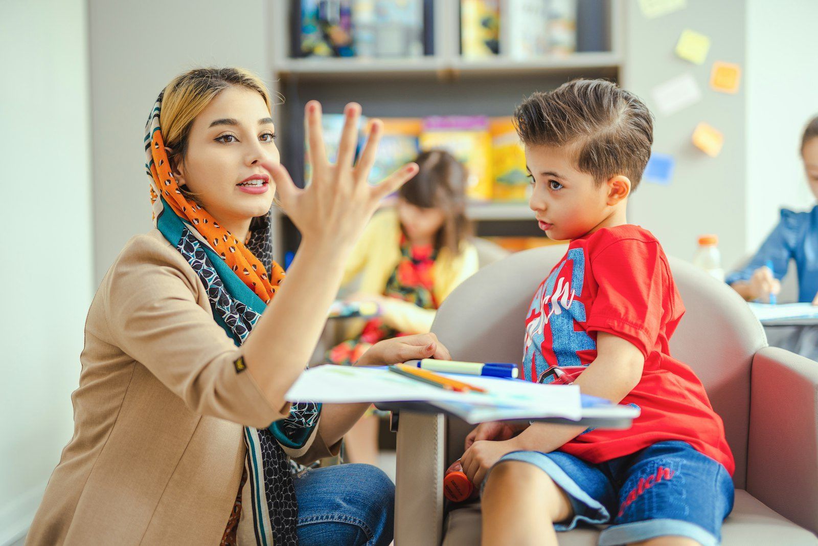 A therapist working with a young child at a table