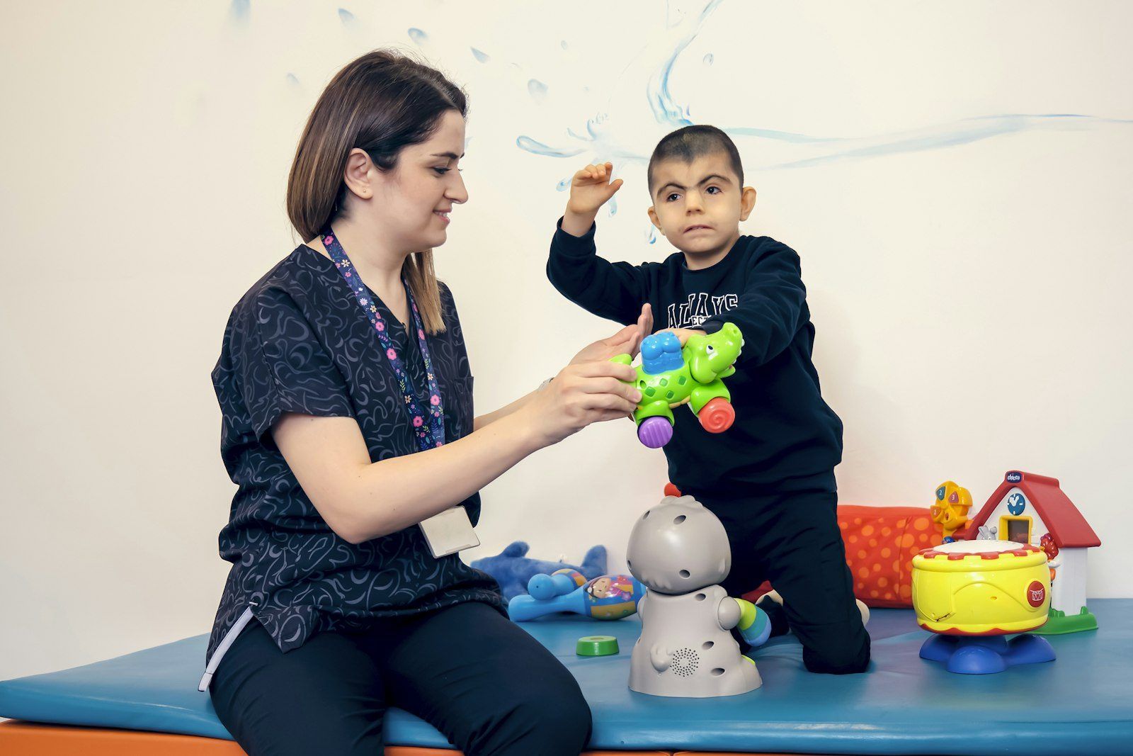 A therapist working with a young child in a bright therapy room
