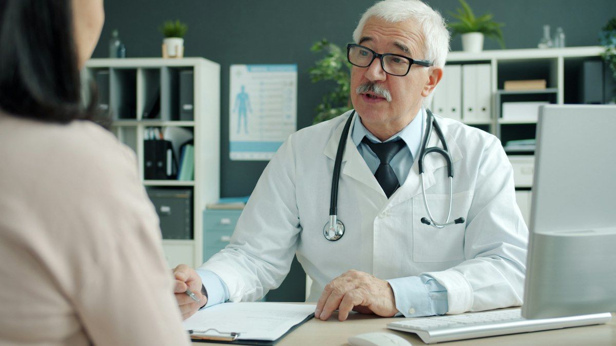 A clinician talking with a patient in a consultation room