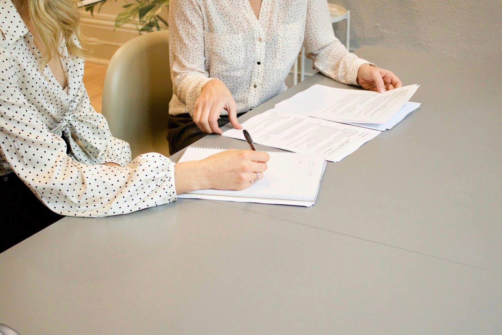 Two people reviewing and signing documents at a table