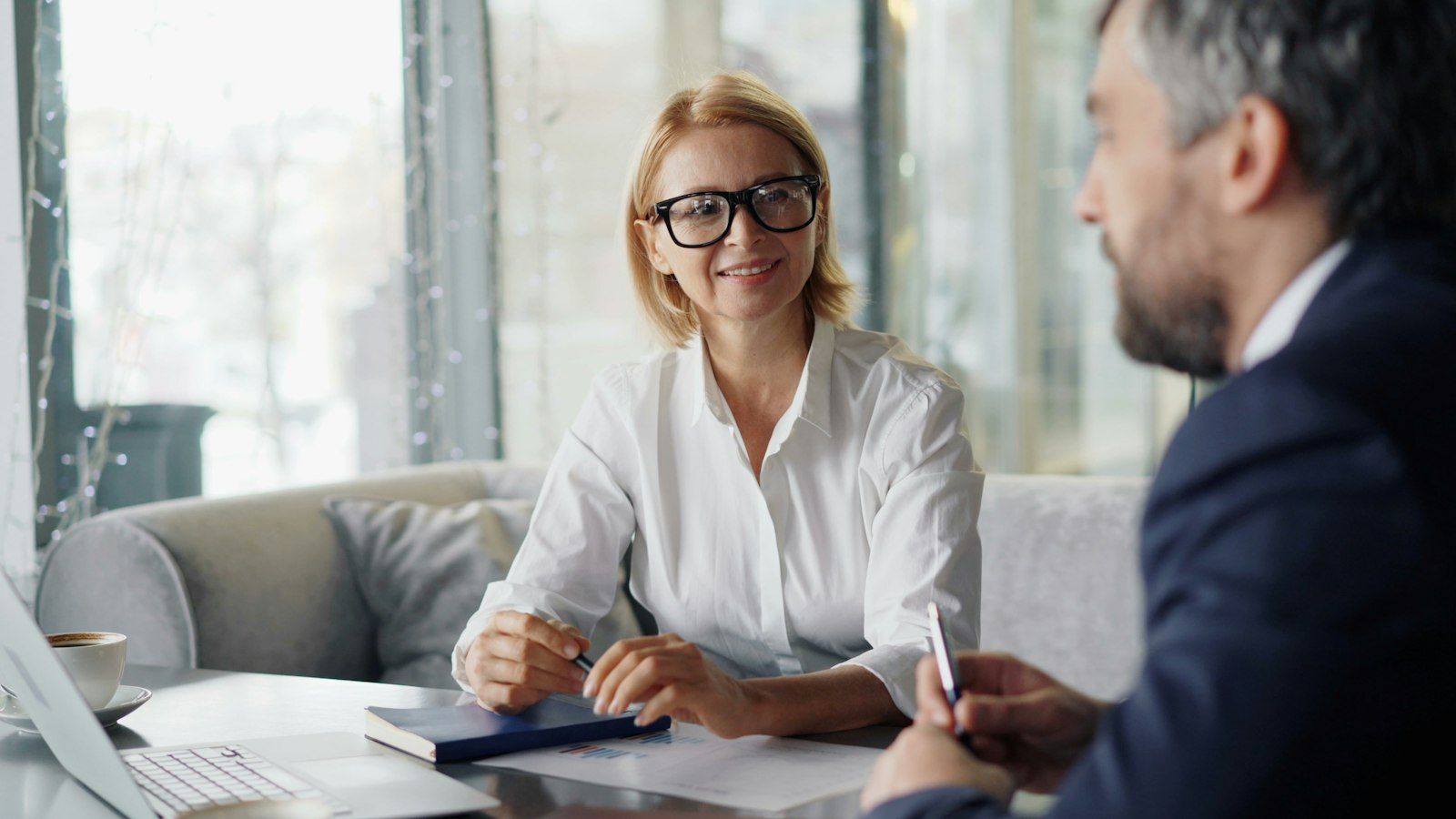 A professional smiling while meeting a client